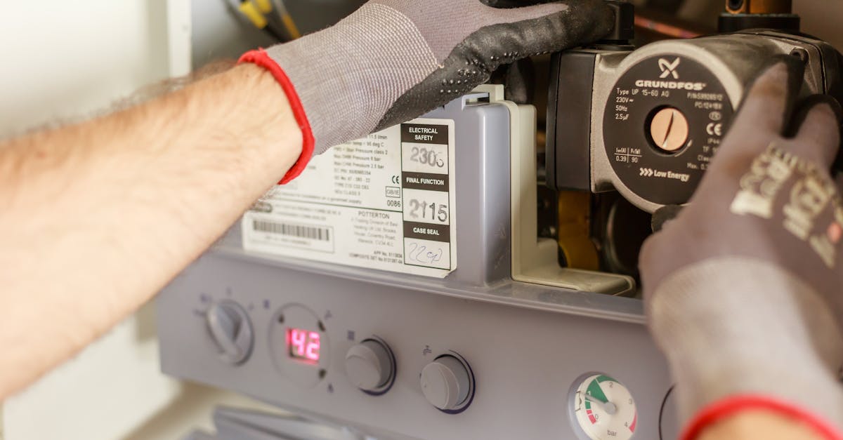 close up of hands adjusting a boiler system with precise instrumentation showing maintenance work